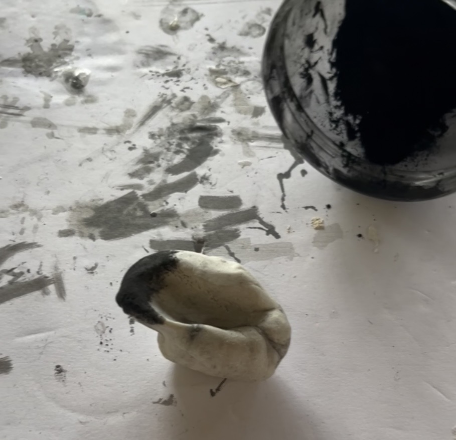 Hand-shaping Eggshell Porcelain with charcoal pigment during the making process.